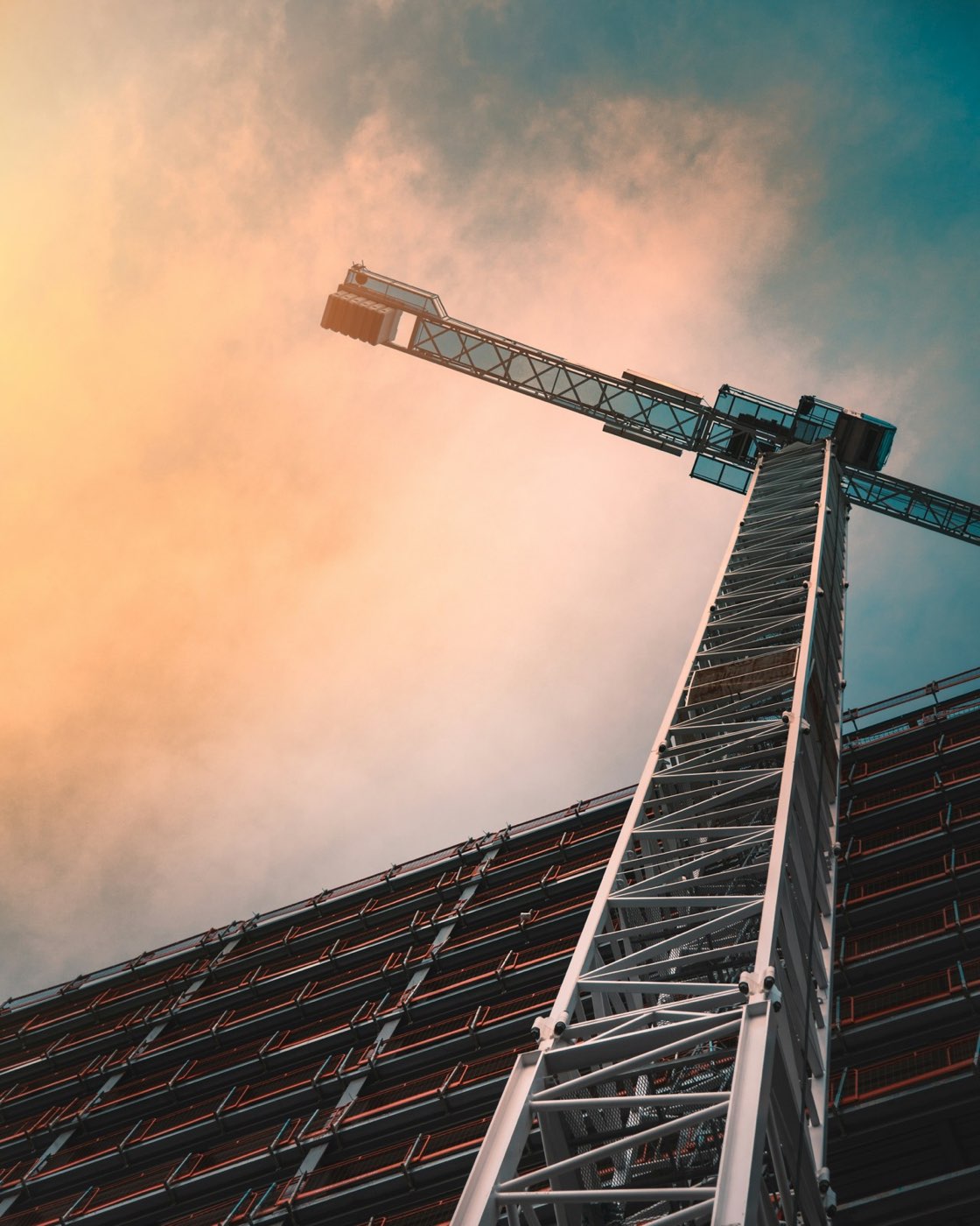 Tower crane rising against the sky — the kind of heavy industrial operation the regional lifting company runs.